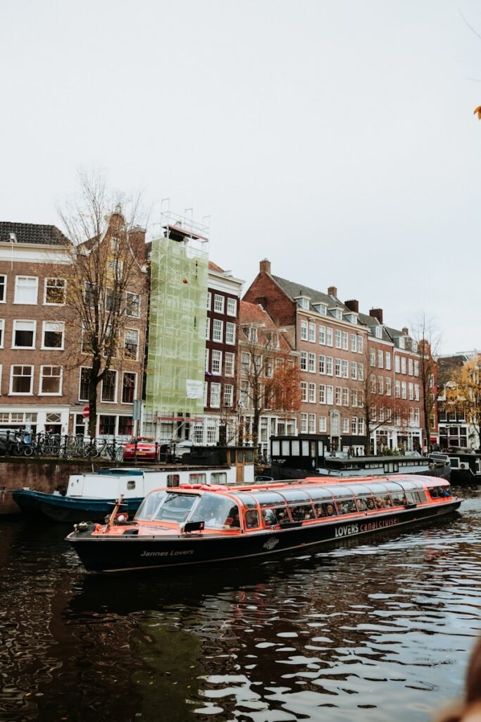 A boat cruises through the canals in amsterdam.